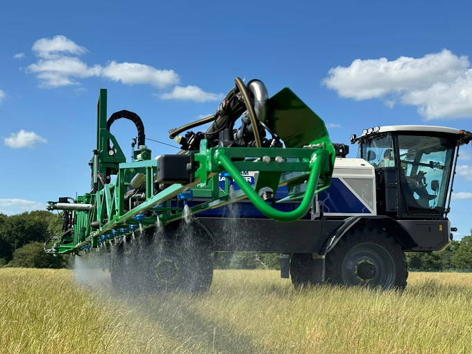 Househam electric crop sprayer working a field